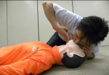 心肺蘇生をする人が、訓練用の人形の人工呼吸をしている動作
