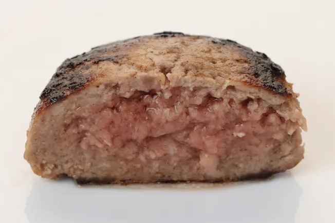 焼いたハンバーグの断面写真。中心部分の肉がまだ赤く生焼けの状態