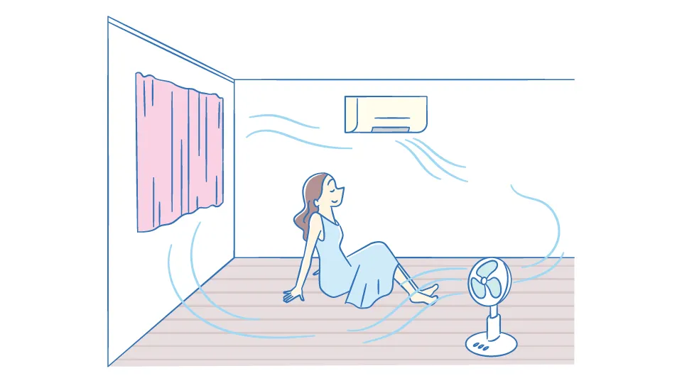 熱中症の予防のため扇風機を併用しながらエアコンを使用している女性