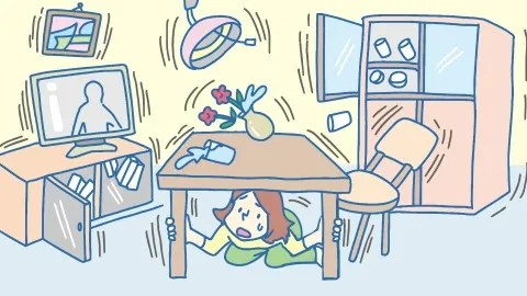 自宅にいるときに地震がきたため、机の下にもぐり、身を守る女性